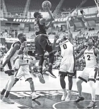  ?? STAFF PHOTO BY ROBIN RUDD ?? VMI’s Bubba Parham takes a jump shot over UTC’s Makale Foreman (0) and Joshua Phillips (2) in the Keydets’ 70-69 win Saturday in McKenzie Arena. Parham had 26 points and seven assists, including the pass for the winning play.