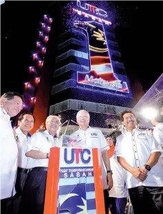  ?? Photo by Aniq Azraei ?? PM Datuk Seri Najib Tun Razak placing a cube on top the UTC Sabah building replica to mark its official opening as CM Datuk Seri Musa Aman (right) and Second Minister of Finance Malaysia Dato’ Seri Ahmad Husni Mohamad Hanadzlah (third left) and other...