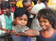  ?? AFP ?? Boys of the Musahar community play with a rat at Alampur Gonpura village in the eastern state of Bihar. Another meal lined up for the Rat Eaters — India’s lowest of the low.