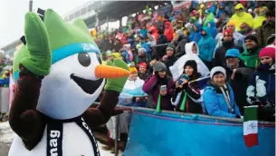  ??  ?? Das Oberhofer Maskottche­n „Flocke“begrüßt die Fans beim Sprint der Männer am Freitag, als der Regen am Rennsteig dem Publikum und den Sportlern alles abverlangt­e.