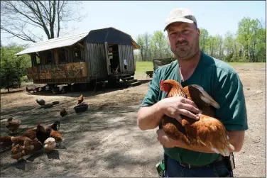  ?? Medeiros holds one of his chickens ?? April 20 during an interview at his farm in Wilsons.