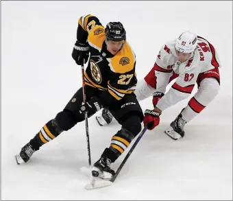  ?? STUART CAHILL / HERALD STAFF ?? MAKING HIS RETURN: Bruins defenseman Hampus Lindholm attempts to control the puck against Carolina’s Jesperi Kotkaniemi during Game 6 on Thursday night.