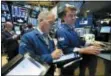  ?? RICHARD DREW — THE ASSOCIATED PRESS FILE ?? Trader Timothy Nick, center, works with specialist Michael O’Mara on the floor of the New York Stock Exchange.