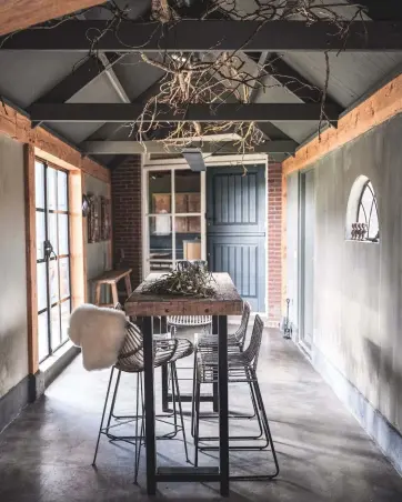  ??  ?? ENTERTAINI­NG SPACE Anneke converted an old garage into a party space, retaining the original features such as the arched window. Table and seating, Herbers Lifestyle