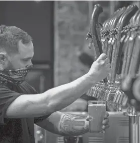  ?? ANDREW NELLES/THE TENNESSEAN ?? Todd Hood, co-owner and brewer, pours a beer for a customer during the weekly history lesson night at Bold Patriot Brewery in Nashville on March 1. Tennessee’s beer and wine taxes are some of the highest in the nation.