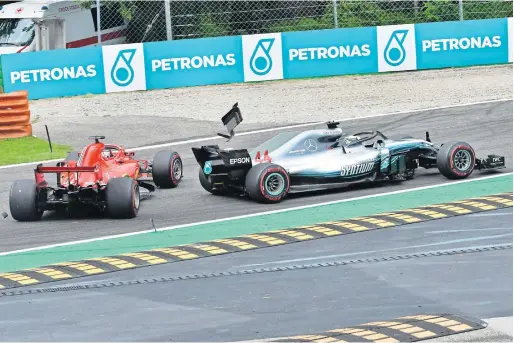  ?? AFP ?? Car parts fly as Mercedes’ British driver Lewis Hamilton (right) and Ferrari’s German driver Sebastian Vettel crash during the Italian Formula One Grand Prix at the Autodromo Nazionale circuit in Monza on Sunday. —