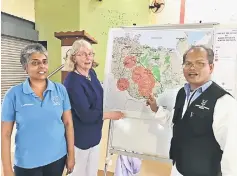  ??  ?? (From left) SSPCA chairman Rebecca D’Cruz and Dr Britton being briefed by a veterinary officer Dr Nicholas Jenek during the mass vaccinatio­n of dogs at Kota Padawan community hall.