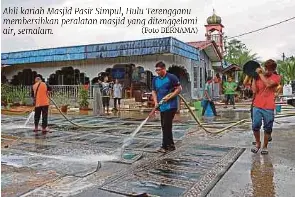  ?? (Foto BERNAMA) ?? Ahli kariah Masjid Pasir Simpul, Hulu Terengganu membersihk­an peralatan masjid yang ditenggela­mi air, semalam.