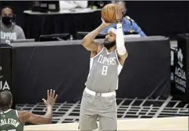  ?? AP photo ?? The Clippers’ Marcus Morris shoots as the Bucks’ Khris Middleton defends during the second half Monday.