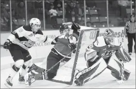  ?? Photo courtesy Tim Smith/The Brandon Sun ?? Linden McCorriste­r (26) of the Brandon Wheat Kings shoves Calen Addison of the Lethbridge Hurricanes into the back of the Hurricanes’ goal behind goaltender Logan Flodell in the first period of game four of the WHL semifinals at Westoba Place.