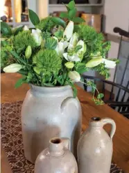  ??  ?? Right: For a classicall­y primitive tabletop arrangemen­t, combine three stoneware pieces in distinctly different sizes and fill one or more of the vessels with fresh flowers, as Sheila did for her dining room table.