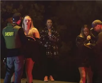  ?? AP PHOTO/MARK J. TERRILL ?? Sheriff’s deputies speak to potential witnesses as they stand near the scene of a mass shooting in Thousand Oaks, Calif., where a gunman opened fire Wednesday night inside a country dance bar crowded with hundreds of people on “college night,” killing at least 12 people, including a sheriff’s deputy who rushed to the scene. One of the survivors was a former Imperial Valley resident, who reportedly was shot in the arm.