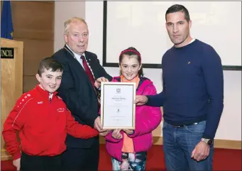  ??  ?? Cathaoirle­ach Cllr Seamus Kilgannon presents a plaque to the Davey family, Jason, Shannon and Seán, as the late Mairéad Davey was honoured at a Civic Reception for the Tubbercurr­y/Cloonacool girls team.