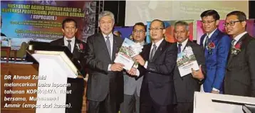  ??  ?? DR Ahmad Zahid melancarka­n buku laporan tahunan KOPROJAYA. Turut bersama, Muhammad Ammir (empat dari kanan).