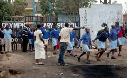  ??  ?? Students run as their school is evacuated for possible attack by supporters of the Opposition, as it was used as a polling station the previous day, in Kibera slum in Nairobi on Friday. —