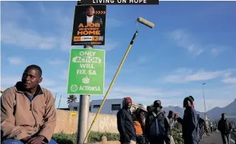  ?? NIC BOTHMA ?? UNEMPLOYED job seekers line a street in Cape Town on Friday waiting for casual employment as they sit beneath campaign posters for the general elections which will be held on May 29. I Reuters