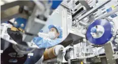  ?? — Reuters ?? The reflection of a worker is seen at the production line of lithium-ion batteries for electric vehicles (EV) at a factory in Huzhou, Zhejiang province, China.