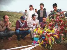  ?? AFP ?? Top and above: Friends and relatives of AFP chief photograph­er Shah Marai Faizi gather at his burial in Gul Dara, Kabul, yesterday.