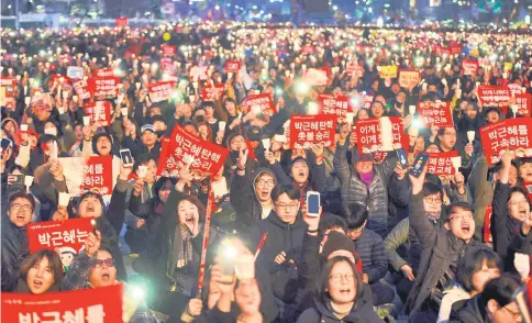  ??  ?? South Korean demonstrat­ors hold up candles during a rally demanding arrest of Park in Seoul, a day after a court upheld her impeachmen­t. — AFP photo