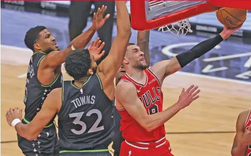  ?? GETTY IMAGES ?? The Bulls’ Zach LaVine gets inside Timberwolv­es defenders Malik Beasley and Karl-Anthony Towns to score two of his 35 points Wednesday.