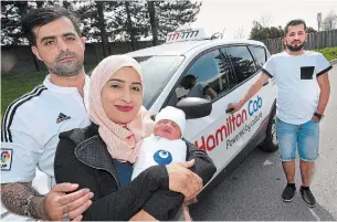  ?? JOHN RENNISON/THE HAMILTON SPECTATOR ?? Proud parents Zeinab and Muneer Mahdi, left, show off their son, Mujataba, who was born Sunday in a taxi driven by Zeinab’s brother, Hussein Jassem, right, on the way to the hospital.