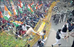  ?? ANI ?? Congress workers try to remove barricades during a protest against the three farm laws in New Delhi on Friday.