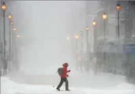  ?? ANDREW VAUGHAN, THE CANADIAN PRESS ?? A skier crosses Barrington Street in downtown Halifax as a major winter storm blasts the Maritimes Monday. The storm was expected to continue through the night and into Tuesday.