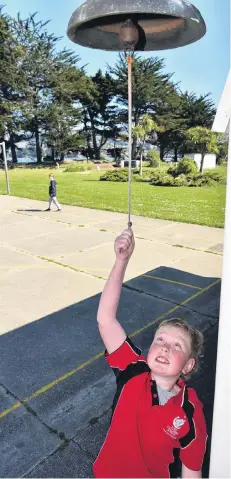  ?? PHOTO: GREGOR RICHARDSON ?? Chiming in . . . Port Chalmers School pupil Jimmy Hill (9) rings the school bell at 1pm yesterday to herald the arrival of the first albatross back to the Taiaroa Head colony.