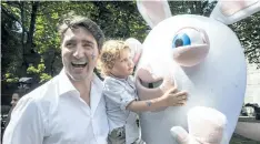  ?? PAUL CHIASSON/THE CANADIAN PRESS ?? Hadrian Trudeau hugs a rabbit while in the arms of his father, Prime Minister Justin Trudeau, at a street party for the Fete National du Quebec, Saturday.