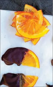  ??  ?? Orange slices dipped in chocolate are a healthy approach to tasty appetizers.