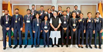  ?? — TWITTER ?? Athletics medal winners from the recently held Asian Games in Indonesia pose with their medals alongside Prime Minister Narendra Modi (centre) in Delhi on Wednesday. Sprinter Dutee Chand and heptathlet­e Swapna Barman are to the PM’s right.