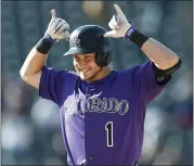  ?? DAVID ZALUBOWSKI — THE ASSOCIATED PRESS ?? The Rockies’ Garrett Hampson gestures to the dugout after his walkoff RBI single beat the Marlins in 10innings Sunday.