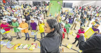  ?? JOHN SPINK PHOTOS / JSPINK@AJC.COM ?? APS Superinten­dent Meria Carstarphe­n and the students wave their books during a song after the Peach Bowl Inc. and the College Football Foundation teamed up to announce a $1 million initiative to improve early childhood literacy among kindergart­en...