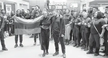  ?? KEVIN RICHARDSON/BALTIMORE SUN ?? Goucher College students gather Friday in the Mary Fisher dining hall to protest racist incidents at the Towson school. The students were led in a chant by Cyd Jones, front left, and Adam Jones, right. The group wore black to symbolize solidarity.
