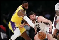  ?? AP Photo/ Marcio Jose Sanchez ?? ■ Los Angeles Lakers' LeBron James, left, strips the ball from Brooklyn Nets' Joe Harris during the first half of an NBA basketball game March 10 in Los Angeles.