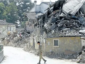  ?? ANTONIO CALANNI/ASSOCIATED PRESS ?? An Italian army soldier walks past rubble in Villa San Lorenzo, near Amatrice, central Italy, on Saturday, where a 6.1 earthquake struck just after 3:30 a.m. last Wednesday.