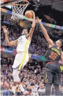  ?? TONY DEJAK/ASSOCIATED PRESS ?? Golden State’s Kevin Durant, left, grabs a rebound during Game 3 of the NBA Finals Wednesday. The Warriors will go for a sweep tonight.