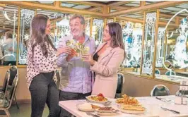  ?? EDRO PORTAL/MIAMI HERALD ?? Felipe Valls Jr. and daughters Nicole, left, and Luly Valls drink mojitos at Versailles, which is marking 50 years as Miami’s most popular Cuban restaurant. An anniversar­y celebratio­n will be held Nov. 10.