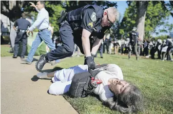  ?? MIKE STEWART, THE ASSOCIATED PRESS ?? A police officer detains a protester on the campus of Emory University in Atlanta during a pro-Palestinia­n demonstrat­ion on Thursday.