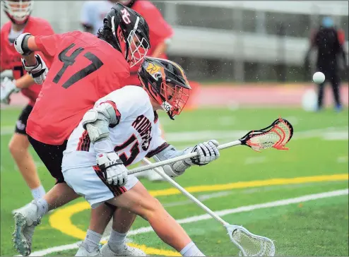  ?? Christian Abraham / Hearst Connecticu­t Media ?? New Canaan’s Dillon Stephens (47) disrupts a drive by Ridgefield’s Kyle Colsey (13) on Thursday.