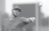  ?? AP Photo/ Gerald Herbert ?? ■ Boston Red Sox starting pitcher Chris Sale warms up as pitchers and catchers report for their first workout at spring training Wednesday in Fort Myers, Fla.