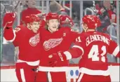  ?? Paul Sancya / Associated Press ?? From left, Red Wings center Andreas Athanasiou celebrates his goal with Tyler Bertuzzi and Luke Glendening Saturday.