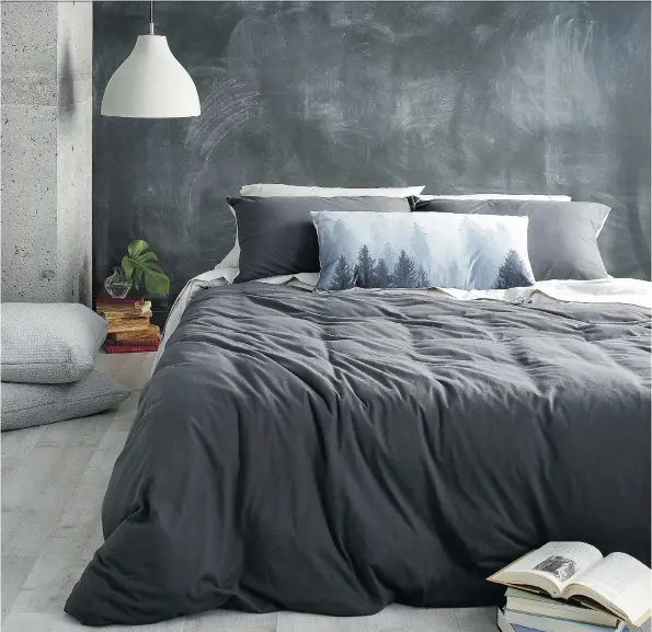  ??  ?? Dressing a bed these days is a matter of personal taste. You don’t need layer upon layer of pillows, blankets and shams. Here, a charcoal grey jersey duvet from Simons is offset by a Foggy Landscape panoramic cushion that conveys a sense of calm and...