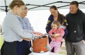  ?? CITIZEN PHOTO BY JAMES DOYLE ?? Dustin Zolnai, Kat Kostukevic­h and daughter Quinn, 2, try their hand at making ice cream with the help of heritage interprete­rs Danica Hoffort and Hailey Friesen on Sunday at Huble Homestead’s Spring on the Homestead event.