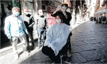  ?? | Reuters ?? A HAIRDRESSE­R works on a street as a protest against the prolonged closure of his business, as Italy begins a staged end to a nationwide lockdown due to the spread of the coronaviru­s disease in Naples, yesterday.