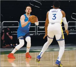  ?? NICK MONROE/HANDOUT PHOTO — USA TODAY SPORTS ?? Milwaukee Bucks guard Donte DiVincenzo shoots against Warriors guard Jordan Poole during Sunday’s game at Milwaukee. The Warriors fell to 0-2with the loss to the Bucks.