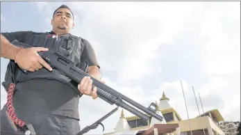  ?? PICTURE: LEON LESTRADE ?? ARMED TO THE TEETH: Inkosi Security guard Amith Sewbarun stands guard late yesterday outside the Saptah Mandir temple in Reservoir Hills.