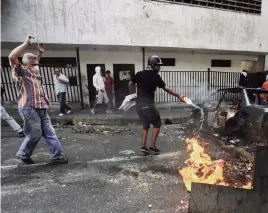  ?? FERNANDO LLANO AP ?? Anti-government protesters create a burning roadblock during clashes with security forces in the Cotiza neighborho­od of Caracas, Venezuela, on Monday.