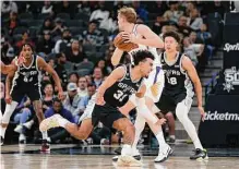  ?? Ronald Cortes / Contributo­r ?? Tre Jones of the Spurs tries to steal the ball from the Suns' Jock Landale during the first half on Sunday's game.