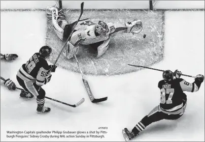  ?? AP PHOTO ?? Washington Capitals goaltender Philipp Grubauer gloves a shot by Pittsburgh Penguins’ Sidney Crosby during NHL action Sunday in Pittsburgh.